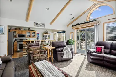 a living room with leather furniture and a kitchen at Boulder Bay Waterfront Breeze in Big Bear Lake