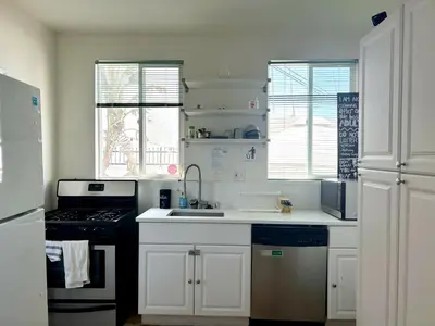 a white kitchen with a sink and a stove at Los Angeles Cozy Vibe in Los Angeles