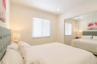 a white bedroom with two beds and a mirror at Sunny 1 Bedroom in the Heart of Venice Beach - #4 in Los Angeles