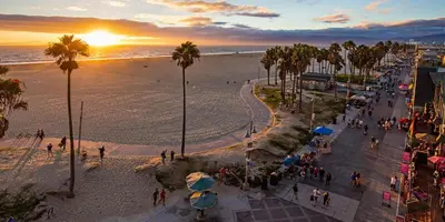 a group of people walking on the beach at sunset at Sunny 1 Bedroom in the Heart of Venice Beach - #4 in Los Angeles