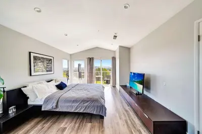 a bedroom with a large bed and a flat screen tv at Stunning Hilltop 5BR With View And Hot Tub! in Lakeside Park