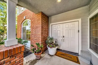 a front door of a brick house with potted plants at Stunning Hilltop 5BR With View And Hot Tub! in Lakeside Park