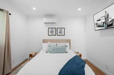 a bedroom with a white bed with a blue blanket at Spanish Style Guesthouse Unit 1 in Los Angeles