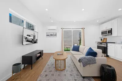 a white living room with a couch and a table at Spanish Style Guesthouse Unit 1 in Los Angeles