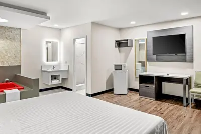 a hotel room with a bed and a flat screen tv at La Mirage Inn - Long Beach in Long Beach