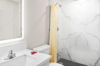 a bathroom with a sink and a shower at La Mirage Inn - Long Beach in Long Beach