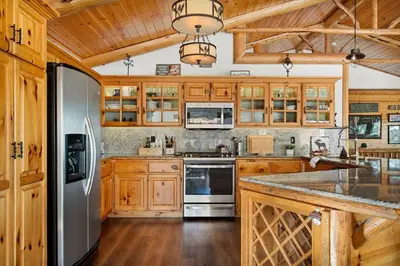 a kitchen with wooden cabinets and a stainless steel refrigerator at Its a Wonderful Lodge in Big Bear Lake