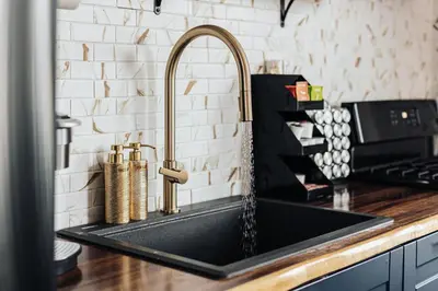 a kitchen sink with a gold faucet at Off The Hook in Big Bear Lake in Big Bear Lake