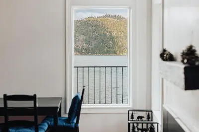 a dining room with a view of the water from a window at Off The Hook in Big Bear Lake in Big Bear Lake