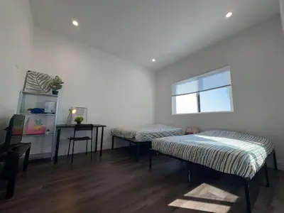 a room with two beds and a table and a window at Blue Private Room near BMO Stadium USC and K-Town in Los Angeles