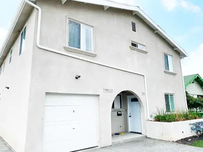a white house with two garage doors at Blue Stay near BMO Stadium and USC Private Room in Los Angeles