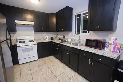 a kitchen with black cabinets and a white stove at Blue Stay near BMO Stadium and USC Private Room in Los Angeles