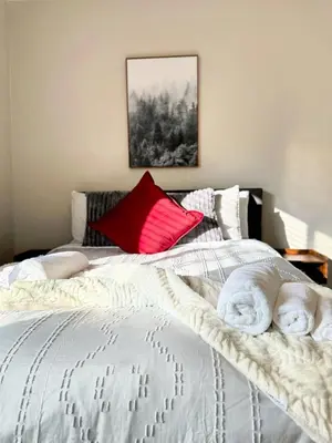 a bedroom with a white bed with a red pillow at Fire Support 3Bedroom Modern Luxury House in Central Pasadena in Pasadena