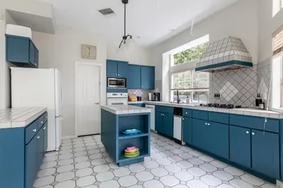 a kitchen with blue cabinets and a white refrigerator at Tranquil family beach city retreat in Redondo Beach