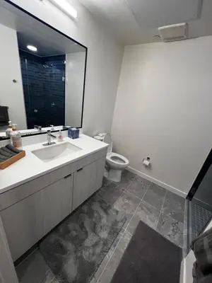 a bathroom with a sink and a toilet and a mirror at Heart of Hollywood-Walk of Fame 1bd Studio with View -Free parking, balcony, wifi, rooftop, gym, upscale amenities in Los Angeles