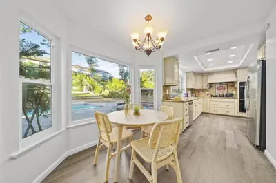 a kitchen with a table and chairs and windows at Luxe Sundance Villa 3BR with Pool and Spa Near Disney in Pomona