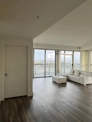 a living room with two white couches and a large window at NoHo in Los Angeles