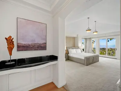 a white bedroom with a bed and a painting on the wall at Savona Sanctuary Estate in Los Angeles