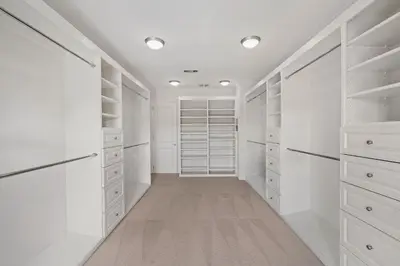 a walk in closet with white cabinets and lights at Savona Sanctuary Estate in Los Angeles