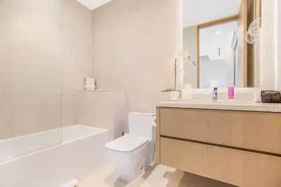 a white bathroom with a toilet and a tub and a sink at Hutton Modern in Beverly Hills