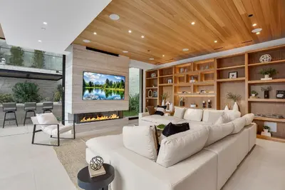 a living room with a large white couch and a fireplace at Hutton Modern in Beverly Hills