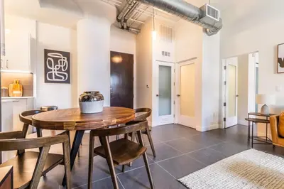 a dining room with a wooden table and chairs at DTLA 2BR Rooftop Jacuzzi & Sunset Views in Los Angeles