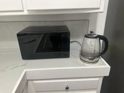 a black microwave sitting on a counter with a blender at Cute room in best area of Hollywood in Los Angeles