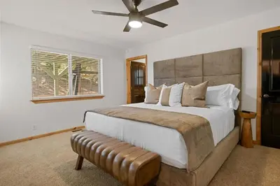 a bedroom with a large bed and a ceiling fan at NEW Serenity Lodge Base Of Snow Summit Hot Tub in Big Bear Lake