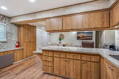 a large kitchen with wooden cabinets and a table at Newly Renovated Home Spacious Close 2 Hospital in San Bernardino