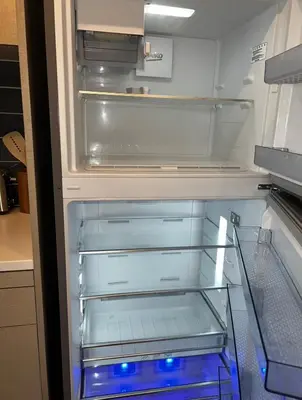 an empty refrigerator with blue lights in it at Modern Hollywood Walk of Fame Apts- Free Parking, 360 Rooftop, Pool, Gym- Centrally located in Los Angeles