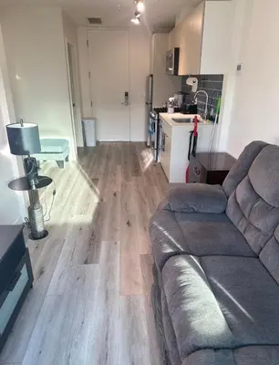 a living room with a couch and a kitchen at Modern Hollywood Walk of Fame Apts- Free Parking, 360 Rooftop, Pool, Gym- Centrally located in Los Angeles