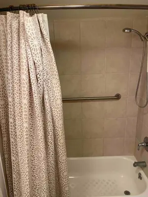 a bathroom with a shower curtain and a tub at Serene Sherman Oaks Cottage with Outdoor Space in Los Angeles