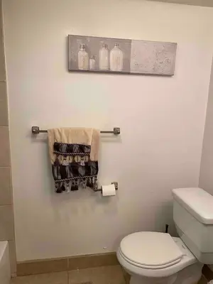 a bathroom with a toilet and towels on a wall at Serene Sherman Oaks Cottage with Outdoor Space in Los Angeles