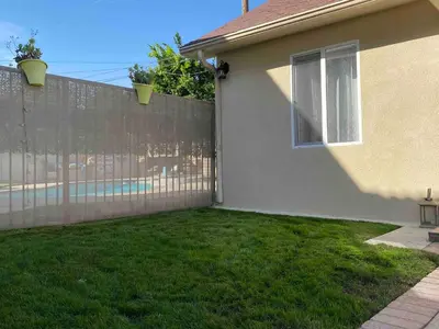 a fence in a yard next to a house at Serene Sherman Oaks Cottage with Outdoor Space in Los Angeles