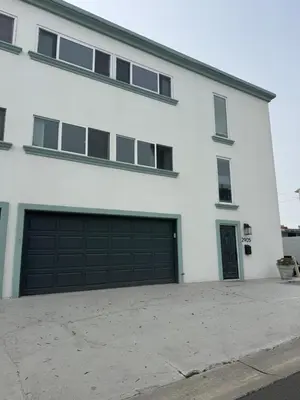 a white building with two garage doors at Manhattan Beach Oasis in Manhattan Beach