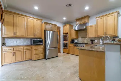 a kitchen with wooden cabinets and a stainless steel refrigerator at Los Angeles Large Mediteranian Vacation Home in Sherman Oaks Community Hospital Heliport