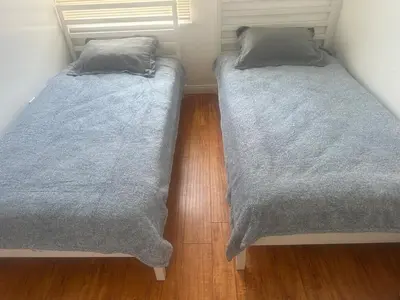 two twin beds in a room with wooden floors at Best location of Hollywood, great room in 2bdrm apt, walk of fame in Los Angeles
