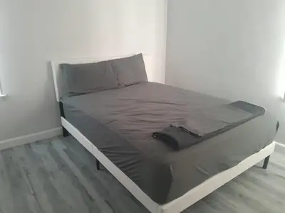 a bed in a white room with a gray mattress at West LA Chariton in Los Angeles