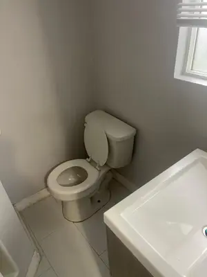 a white bathroom with a toilet and a sink at West LA Chariton in Los Angeles