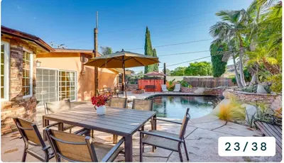 a table with chairs and an umbrella next to a pool at Emeric Estate in Simi Valley