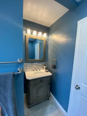 a blue bathroom with a sink and a mirror at Faith House in Los Angeles