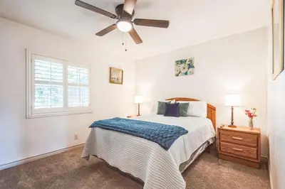 a bedroom with a bed and a ceiling fan at Peaceful Oasis in Anaheim