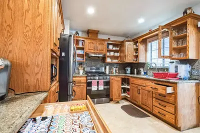 a kitchen with wooden cabinets and a black refrigerator at Peaceful Oasis in Anaheim