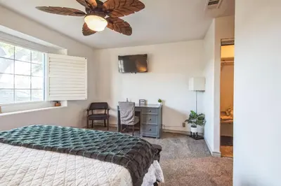 a bedroom with a bed and a desk and a window at Peaceful Oasis in Anaheim