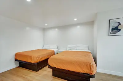 two beds in a room with white walls and wood floors at Casablanca Inn in Bell
