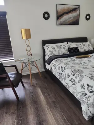 a bedroom with a bed and a chair and a table at Travelers Mini Stays - Revelation Nation Welcome in Simi Valley
