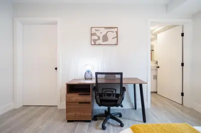 a desk with a chair in a room with white walls at Cozy Urban Retreat near Downtown LA & USC - Private room with shared Living room and kitchen in Los Angeles