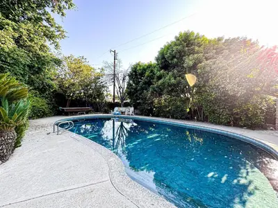 a swimming pool with blue water in a yard at Cozy 1-BR Poolside Getaway in West LA - LOU2 - WW in Los Angeles