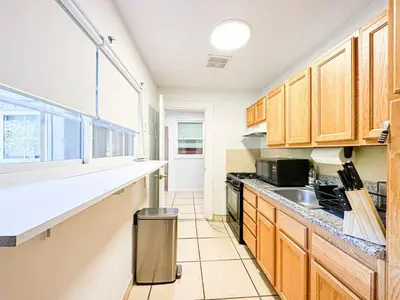 a kitchen with wooden cabinets and a counter top at Cozy 1-BR Poolside Getaway in West LA - LOU2 - WW in Los Angeles
