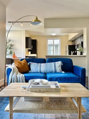 a blue couch in a living room with a table at 2BD 2BA Santa Monica Apartment with Relaxing Pool View in Los Angeles